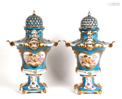 A large pair of continental porcelain potpourri, decorated with cherubs within panels, on a blue