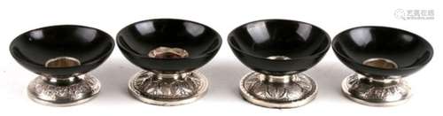 Two pairs of Indonesian silver and horn candlesticks, with dish shaped bowls above a heavily