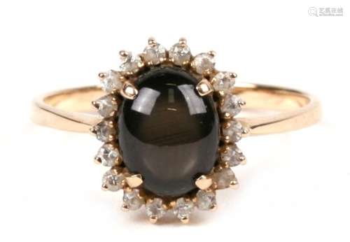 A 14ct gold dress ring set with a central black cabochon, approx UK size 'S'.