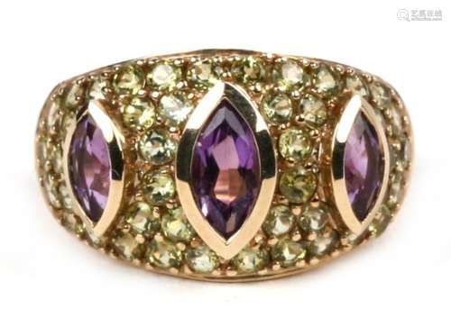 A 9ct gold dress ring set with three amethysts and a multitude of green stones, approx UK size 'L'.