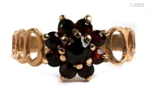 A 9ct gold and garnet cluster pierced shoulder ring, 1.9g. Approx.UK size L.