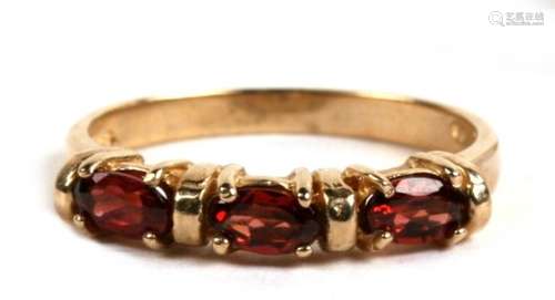 A 9ct gold and three stone garnet ring, 2.4g. Approx. UK size N.