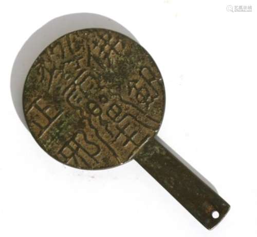 An antique Chinese bronze mirror with concave surface and decorated with calligraphy to the