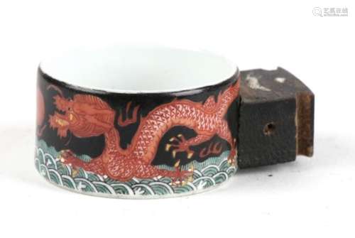 A 19th century Chinese porcelain bird feeder decorated with a pair of red dragons chasing a