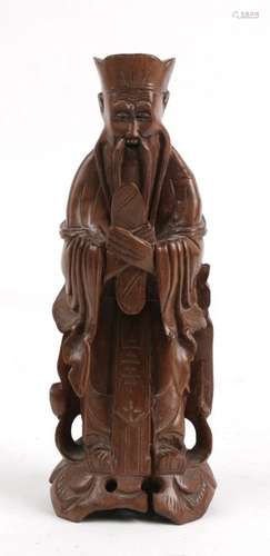 A Chinese carved hardwood figure in the form of a robed scholar, 20cms (8ins)