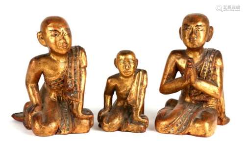 A group of three 19th century Burmese lacquer gilded and inlaid praying figures of priests, dated