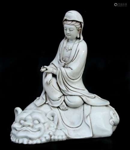 A Chinese Blanc de Chine style figure, depicting Guan Yin sat on a temple lion. 30cm 12ins high.