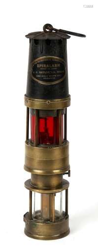 A Spiralarm miners lamp for the detection of dangerous gases. Clear glass lamp base with red alarm