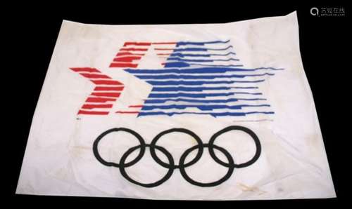 A large 1984 Los Angeles Olympic flag, with the Stars in Motion logo over the Olympic rings.