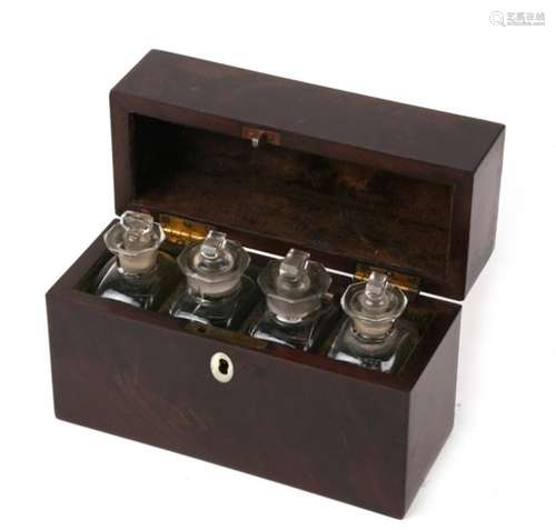 An early 19th century mahogany travelling bottle box containing four glass bottles, 17cms (6.5ins)