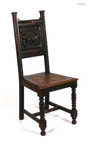 A continental oak hall chair with carved panel back depicting two figures drinking at a table.