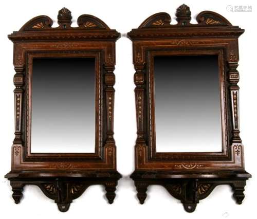 A pair of cast iron wall mirrors with candle shelves and ornate columns having enamelled