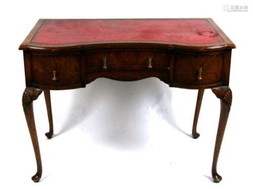 An Edwardian ladies writing table with inset red leather top above a central frieze drawer flanked