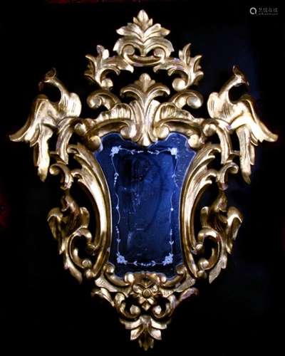 A carved gilt wood mirror with etched glass plate, overall 58 by 74cms (23 by 29ins).Condition