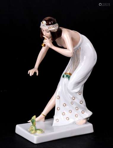 A Rosenthal porcelain figure of a snake charmer, decorated with green and gilt. Modelled by Berthold