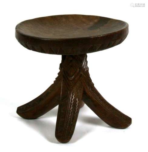 Tribal Art. A Nigerian stool carved from a single piece with four splayed legs and all over