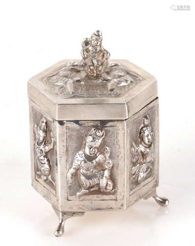 A Burmese silver lidded box of hexagonal form, decorated in relief with figures 9cm 3.5ins high