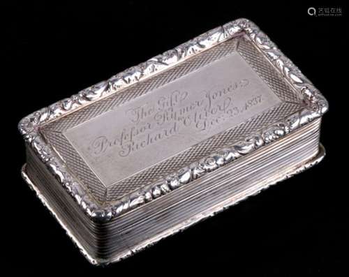 A large rectangular silver snuff box with reeded decoration and raised floral banding all round.