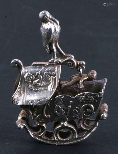 A 19th century Dutch miniature silver group of a rocking crib with a stork above holding a baby. 5.