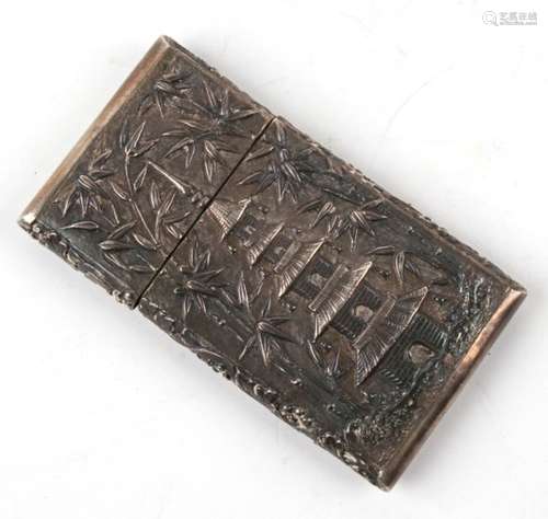 A Chinese silver card case with all over embossed decoration depicting figures in a garden and a