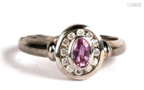 A 9ct white gold ring set with a central oval pink tourmaline surrounded by diamonds, approx UK size