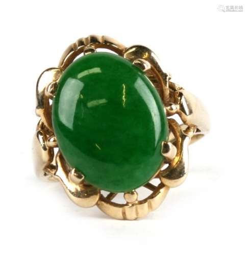 An 18ct gold ring set with an oval jade cabochon, approx UK size 'L'.