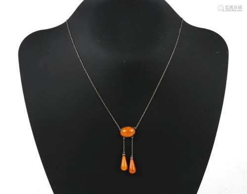 A silver and amber necklace, the oval amber cabochon with two amber drops below.