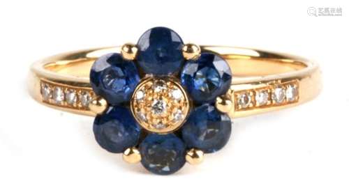 An 18ct gold sapphire daisy ring, with central diamond cluster and diamond inset shoulders. 3.9g.