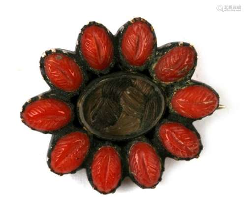 A Georgian gold mourning brooch, a central glazed panel containing plaited hair surrounded by a