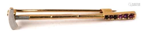 An 18ct gold and ruby novelty bar brooch modelled as a polo mallet, unmarked but tested, 2.3g. 4.3cm