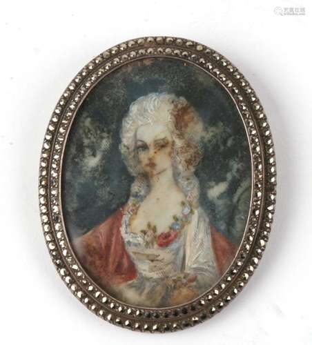 A silver and marcasite oval brooch containing a watercolour portrait miniature of a young woman