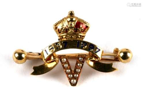 An 18ct gold and enamel brooch set with seed pearls depicting the letter V below a scroll and crown,