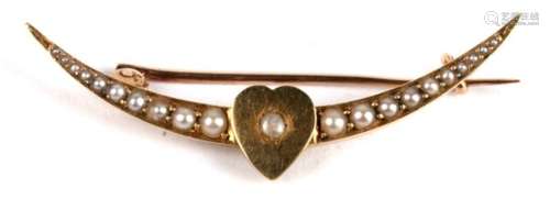 An 18ct gold (unmarked but tested) crescent shaped bar brooch with heart shaped central motif, set