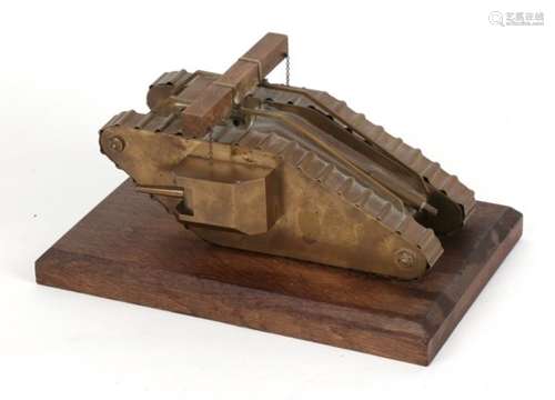 A detailed scratch built brass model of a WW1 tank with moving machine guns mounted on a hardwood