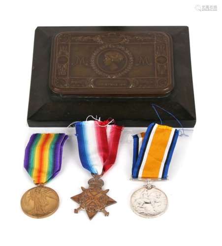 A WWI Princess Mary Xmas tin mounted in a Bakelite plinth together with a WWI trio of medals named