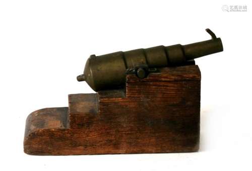 A 19th century bronze signal cannon with front and rear sights mounted on a solid wood static