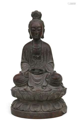 A Chinese bamboo carving in the form on Guanyin seated on a lotus flower, 29cms (11.5ins) high.