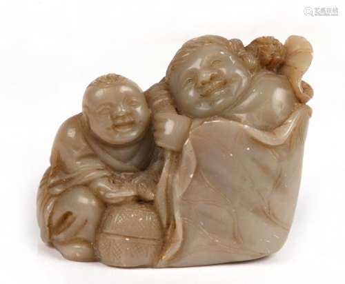 A Chinese soapstone group depicting two figures, one holding a lily pad, the other by a basket, 6cms