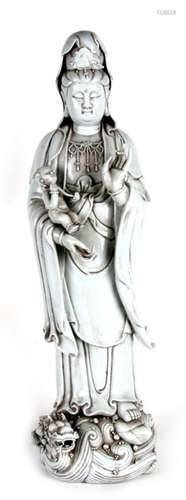 A Chinese Blanc de Chine style figure, depicting Guan Yin carrying a small child holding a rui