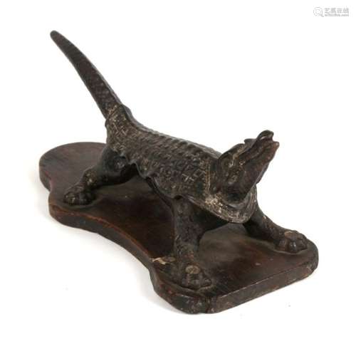 A 19th century cast iron cork press in the form of a stylised crocodile, 29cms (11.5ins) long.