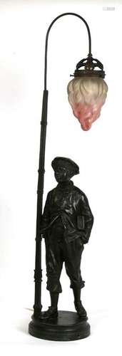 A bronzed spelter figural lamp in the form of a young boy holding a book beside a lamp post,