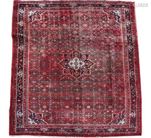 A Persian Hamadan woollen hand knotted rug with central floral medallion with floral borders on a