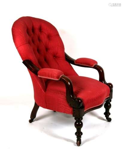 A Victorian button backed upholstered arm chair on turned front supports