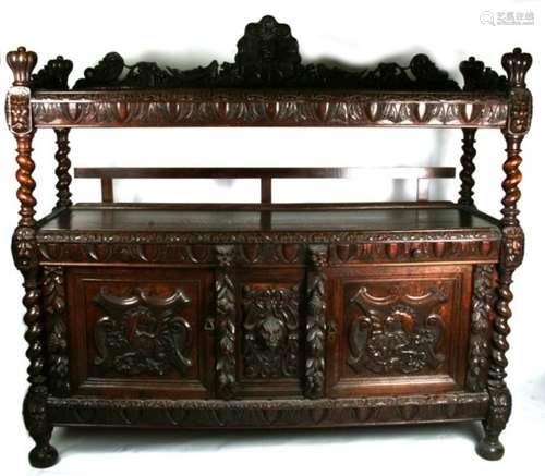 An impressive Victorian two tier carved oak sideboard, the upper section carved with lion mask,