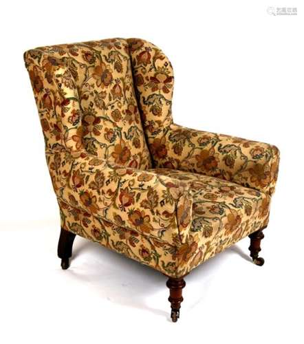 A Victorian wing back armchair on turned front supports, upholstered in William Morris style