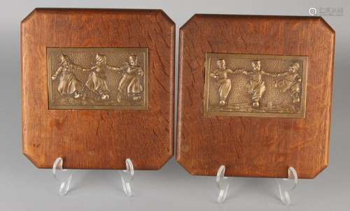 Two antique bronze plaques in oak frames. Dutch girls.