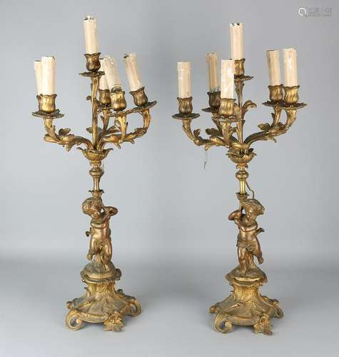 Two gilded bronze candlesticks with putti. Circa 1900.