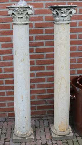 Two antique sandstone Corinthian columns with capitals.