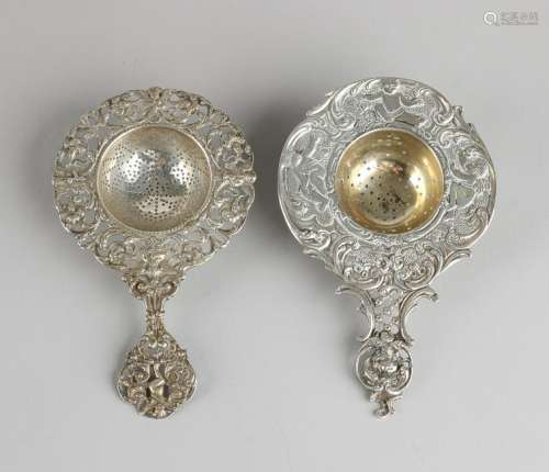 Two silver tea strainers, single cutaway model with