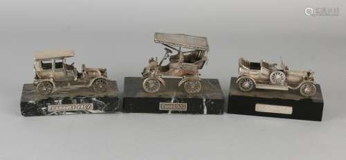 Three silver cars on basement. 835/000. A Ford 1903, a